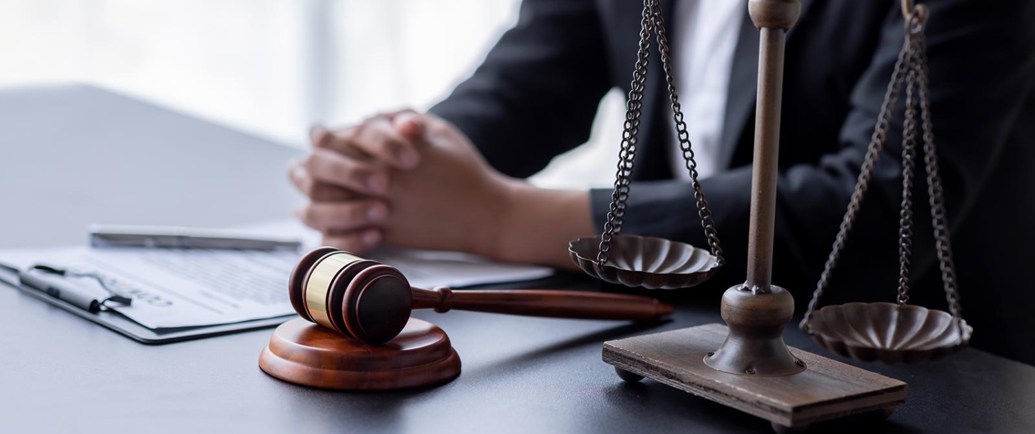 Wide panorama view of lawyer working with contract papers and wooden gavel on tabel